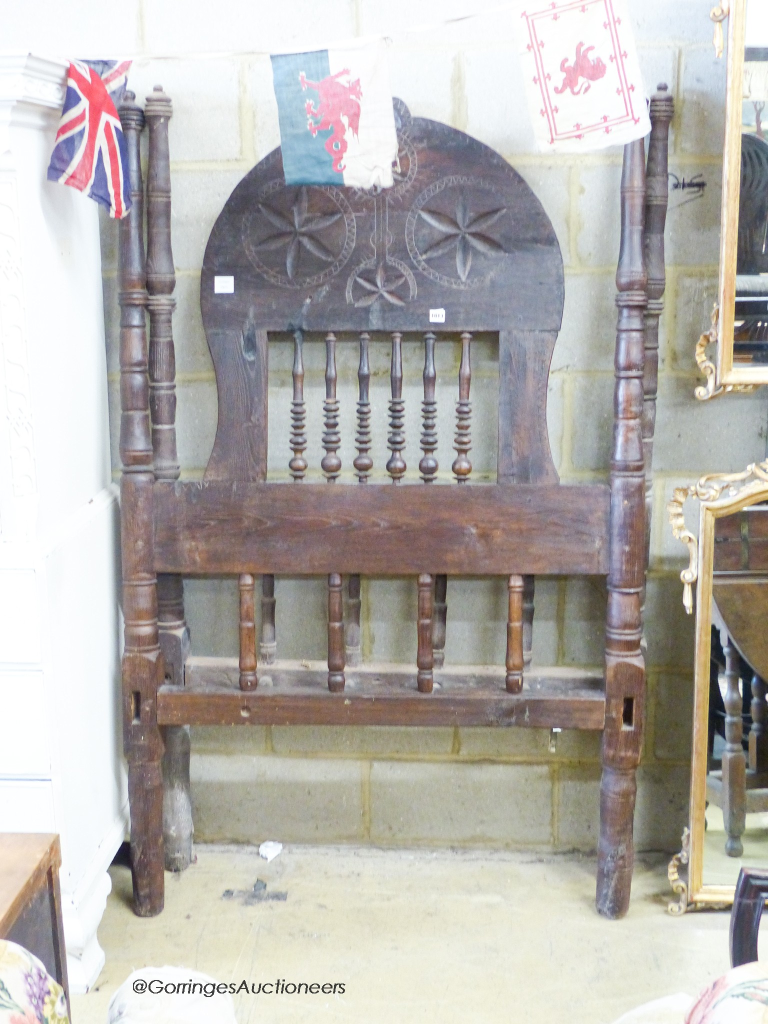 An Eastern European carved head and foot single bedstead, W.110cm H.178cm